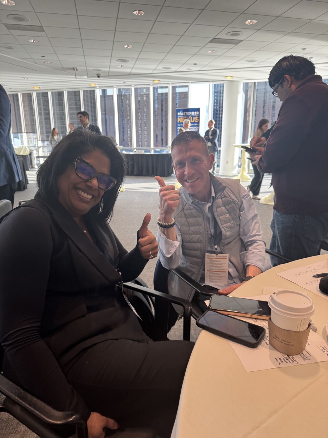 Two attendees smiling at a roundtable